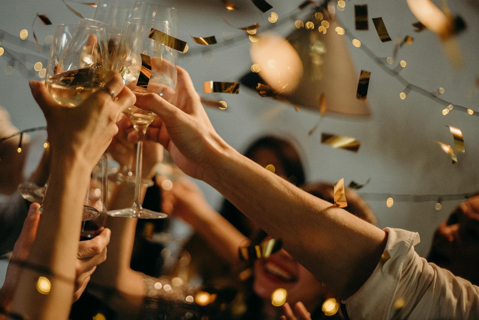 Champagne toast with gold confetti and string lights
